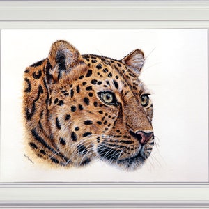 The finished leopard painting in a white frame.