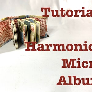 May include: A tutorial on how to make a harmonica micro album. The album is made of paper and fabric and has a floral design. The album is closed and folded in half.
