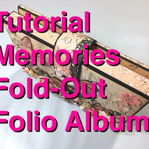 Op de afbeelding: Een decoratief uitvouwbaar folio-album met de tekst "Tutorial Memories Fold-Out Folio Album" in felroze. Het album heeft een vlinderontwerp en bloemversieringen. Het album is beige met zwarte rand.