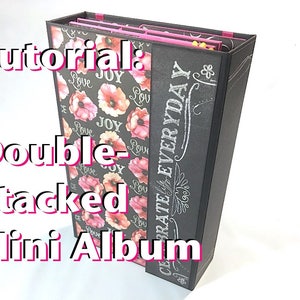 Puede incluir: Un mini álbum en blanco y negro con un diseño floral y el texto "Celebrate Everyday" en el lomo. El álbum está apilado doblemente y tiene un interior rosa.