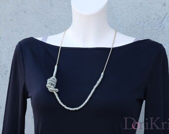 Gold and silver chain necklace featuring a Metal knot