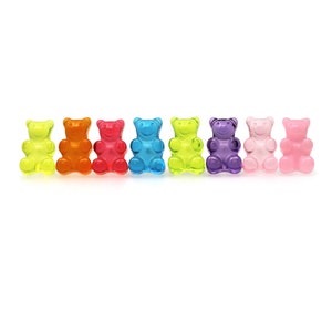 May include: Seven translucent gummy bear sweets in a row, in colours including yellow, orange, red, blue, green, purple, and pink. Each bear has the classic gummy bear shape.