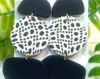 May include: Black and white patterned circle earrings with black teardrop shaped earrings. The earrings are handmade and the card reads "Curvy Leopard Jewellery Designs" and "Handmade Jewellery by Shaz".