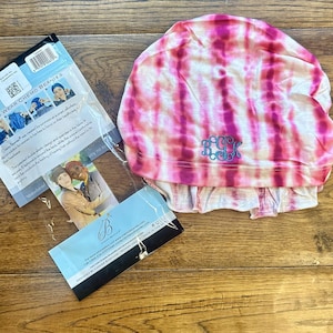 May include: Pink and white tie-dye chemo beanie with the monogram "K.C.K." embroidered in blue thread.