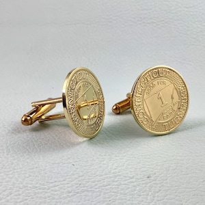 May include: Gold-toned cufflinks with a coin-like design. Each cufflink features the text "Connecticut Fare" and "Good for 1". The cufflinks have a classic, elegant style, suitable for formal wear.