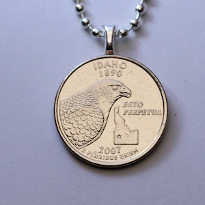 May include: Silver pendant necklace featuring a quarter coin with an image of a hawk and the state of Idaho. The coin reads "Idaho 1890 Esto Perpetua 2007 E Pluribus Unum".