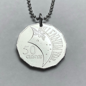 May include: A silver 50 cent Australian coin necklace with a design featuring the Australian flag and the words "Millennium Year".