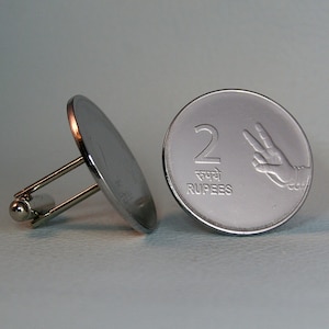 May include: Silver cufflinks featuring a 2 Rupees coin from India. The coin has a raised number 2, the word "Rupees" and a hand with two fingers raised.