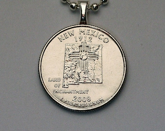 May include: Silver necklace with a New Mexico quarter coin pendant. The coin features the state outline, the Zia symbol, and the text "New Mexico 1912 Land of Enchantment 2008 E Pluribus Unum".