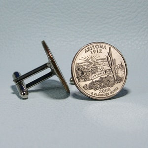 May include: A pair of silver cufflinks featuring a 2008 Arizona quarter with the text "Arizona 1912" and "Grand Canyon State" on the front. The back of the coin features the text "E Pluribus Unum" and "2008".