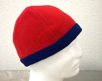 Four-panel hat made of red wool fabric, ornamented with a blue wool band. Head circumference 60 cm.