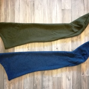 May include: Two long, narrow fabric sleeves, one dark green and one dark blue, are laid out flat on a wooden surface. The sleeves are made of a soft, fuzzy material.