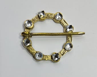 Medieval brooch made of brass with glass pearls.