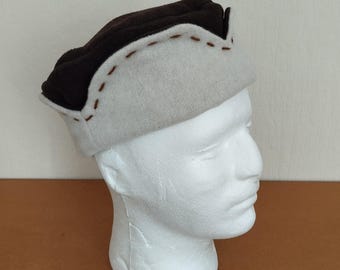 Cap crafted in ecru and brown woolen cloth, ornamented with a brown backstitch, used for medieval reenactment.