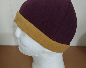 Four-panel hat made of red winewool fabric, ornamented with a wool band. Head circumference 65 cm.