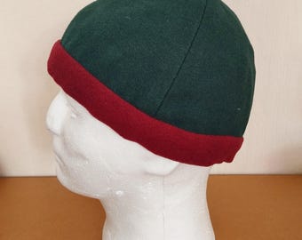 Four-panel hat made of dark green wool fabric, ornamented with a wine wool band. Head circumference 60 cm.