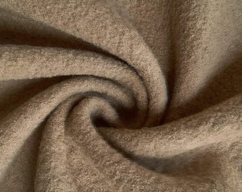 May include: A close-up of a soft, brown, fuzzy fabric. The fabric is folded and draped, showing its texture and color.