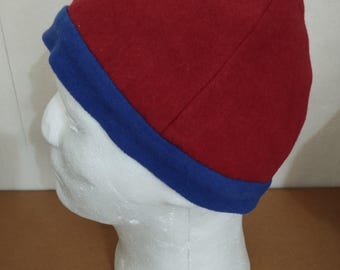 Four-panel hat made of red wool fabric, ornamented with a wool band. Head circumference 59 cm.