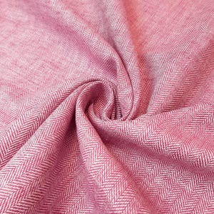 Könnte beinhalten: Rosa-weißer Fischgrätstoff mit einer strukturierten Webart. Der Stoff ist gefaltet und drapiert, wodurch Muster und Textur sichtbar werden.