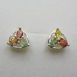 May include: A pair of silver earrings with a triangular design. Each earring features three oval-shaped gemstones in shades of green, orange, and yellow.