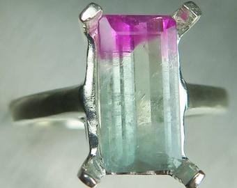 May include: A silver ring with a pink and green tourmaline gemstone set in a prong setting.