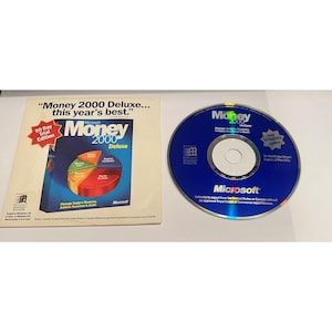 Può includere: CD-ROM del software Microsoft Money 2000 Deluxe con una versione di prova di 90 giorni. Il CD è blu con un logo Microsoft bianco e il testo "Money 2000 Deluxe". La custodia del CD è bianca con un'immagine dell'interfaccia del software e il testo "Money 2000 Deluxe... il meglio di quest'anno."