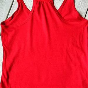 May include: A plain red tank top with a scoop neck and racerback style.