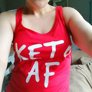 May include: Red tank top with the text "Keto AF" written in white.