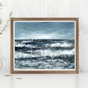 May include: A framed painting of a stormy seascape with white-capped waves crashing against a dark blue ocean. The sky is a light blue with hints of gray clouds.