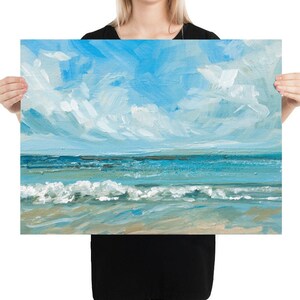 May include: A painting of a seascape with blue water and white clouds in a light blue sky. The waves are crashing on the sandy beach.