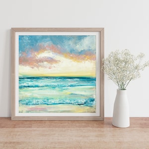 Puede incluir: Una pintura enmarcada de un paisaje mar&iacute;timo con un oc&eacute;ano azul y verde, olas blancas y un cielo de puesta de sol rosa y amarillo.
