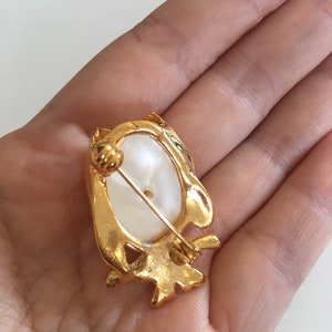 Peut inclure: Broche en forme de hibou dor&eacute;e avec un cabochon ovale blanc au centre. La broche a un fermoir &agrave; &eacute;pingle.