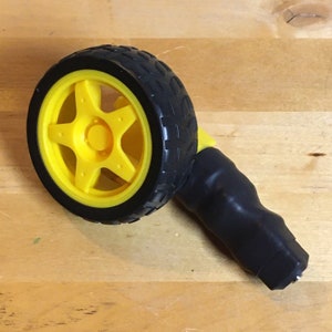 May include: An ab wheel roller with a black tire and a yellow wheel. The wheel has a star-shaped design. The handle is black and has a textured grip. The ab wheel is designed for core strength exercises.