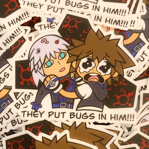 Peut inclure: Un autocollant représentant une illustration de deux personnages de dessin animé, l'un avec des cheveux blancs et l'autre avec des cheveux bruns. Les personnages se tiennent l'un l'autre et ont des expressions de détresse. L'autocollant a un fond blanc avec des contours noirs et des accents rouges. Le texte "They put bugs in him!" est écrit en lettres noires en bas de l'autocollant.