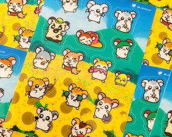 May include: A sheet of colorful stickers featuring cartoon hamsters in various poses and activities. The hamsters are wearing hats, playing musical instruments, and holding objects. The stickers are on a yellow background with a green border.