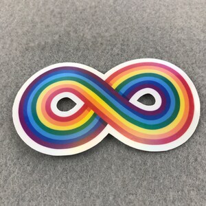May include: A rainbow infinity symbol sticker. The symbol is made up of a series of rainbow stripes that are arranged in a continuous loop.