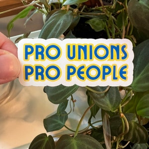 May include: A white sticker with blue and yellow lettering that reads "Pro Unions Pro People".