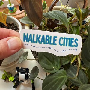 May include: A white sticker with a blue and green outline reads "WALKABLE CITIES" with a dotted line and arrow pointing to the right.