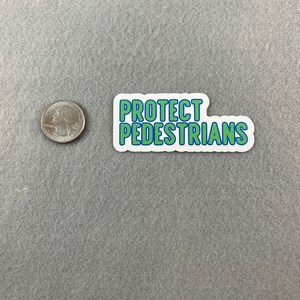 May include: A white sticker with blue and green lettering that reads "PROTECT PEDESTRIANS".