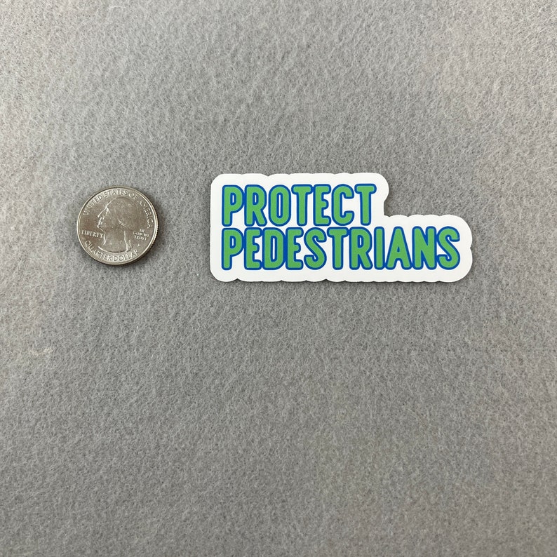 May include: A white sticker with blue and green lettering that reads "PROTECT PEDESTRIANS".