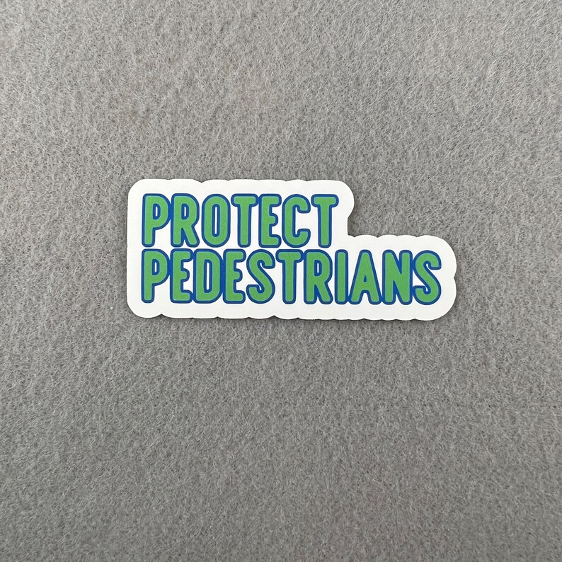 May include: White sticker with blue and green text that reads "PROTECT PEDESTRIANS".