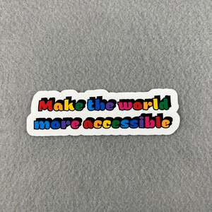May include: A white sticker with the text "Make the world more accessible" in rainbow colors.