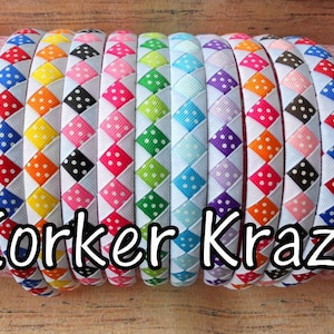 May include: A collection of colorful headbands with a woven design. Each headband features a white ribbon base with a pattern of polka dots in various colors, including red, blue, yellow, and green. The text "Korker Krazy" is displayed in white.