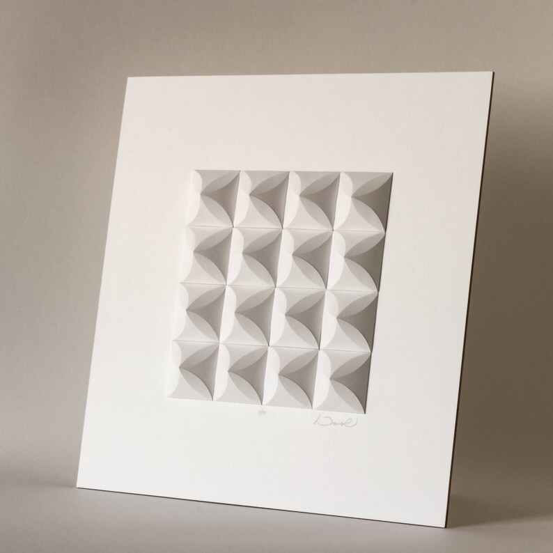 May include: White paper sculpture with a geometric pattern of overlapping circles. The sculpture is framed and signed by the artist.
