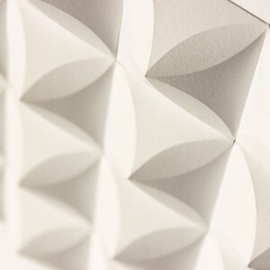 May include: White acoustic panels with a geometric pattern of overlapping circles. The panels are made of a textured material and have a slightly raised surface.
