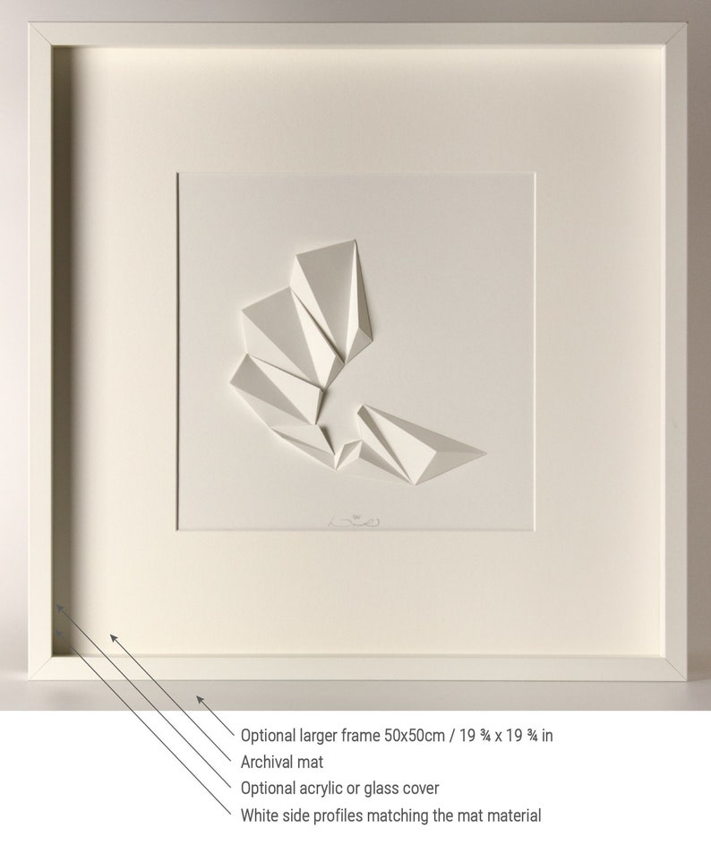 May include: A white framed artwork featuring a white paper sculpture of geometric shapes. The artwork is matted and has an optional larger frame available in 19 3/4 x 19 3/4 inches.