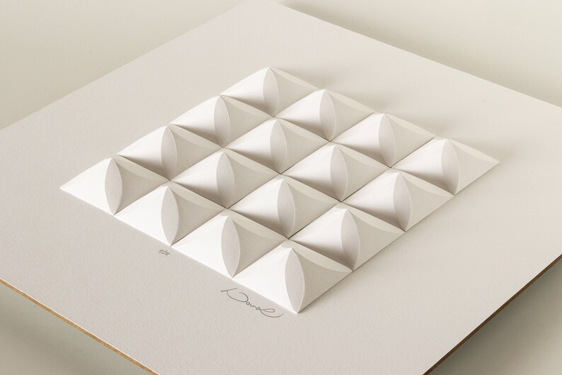 May include: White paper sculpture of a geometric pattern with 16 raised, rounded squares. The sculpture is signed "David" in the bottom right corner.