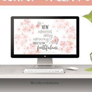 May include: A desktop computer screen displaying a pink floral wallpaper with the text "NEW mercies every morning: GREAT is thy faithfulness..." The computer is on a white desk with a green desk lamp.