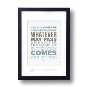 May include: A framed print with a white background and black frame. The print features a typography design with the text "The sun comes up it's a new day dawning It's time to sing your song again Whatever may pass & Whatever lies before me Let me be singing When the evening comes Now the lord is my soul Lostbumblebee".