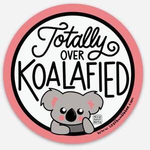 May include: A pink and white round sticker with the text "Totally Over Koalafied" in black cursive font. A cartoon koala with pink cheeks is peeking out from behind the text. The text "www.lostbumblebee.com" is at the bottom of the sticker.